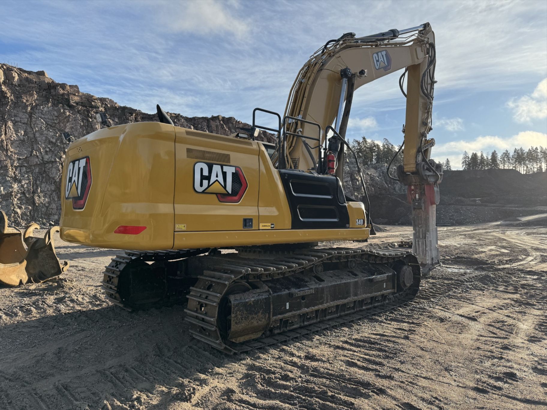 CAT grävmaskin vid bergsvägg