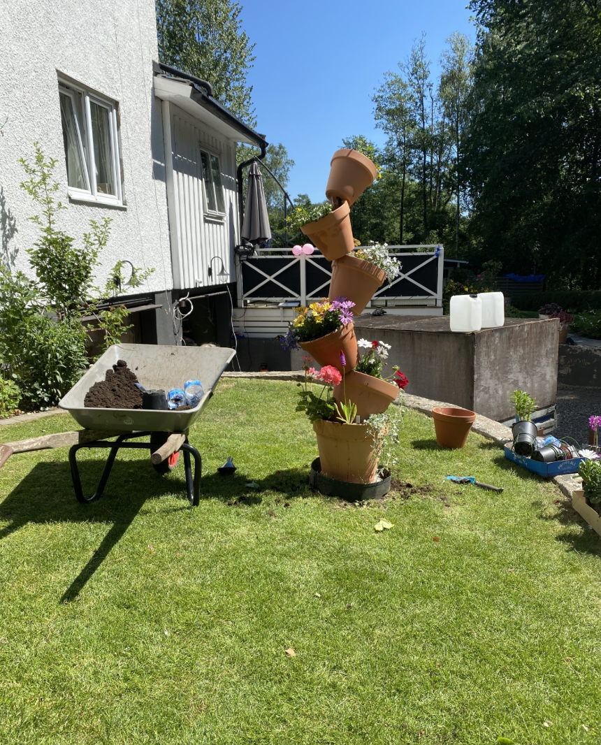 Trädgårdsarbete med blomkrukor och skottkärra